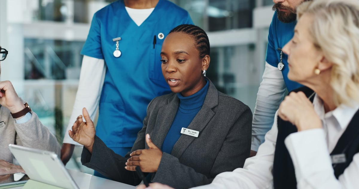 Medical staff reviewing a schedule on a tablet in a hospital