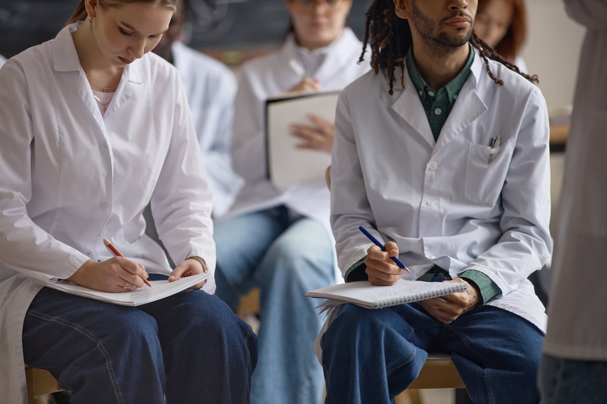 Medical students taking notes during a clinical training session
